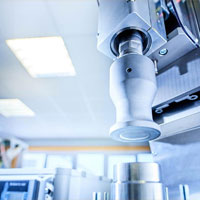 Ultraschall-Schweißwerkzeug in Laborumgebung, zentrale Position, starke Tiefenunschärfe im Hintergrund.