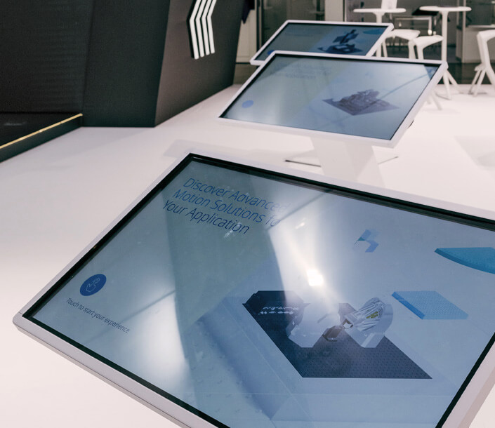 Mehrere interaktive Touchscreen smit digitalen Präsentationen zu Motion-Lösungen.
