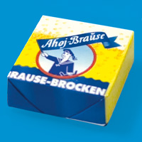 Gelber Ahoj-Brause-Brocken auf blauem Hintergrund.