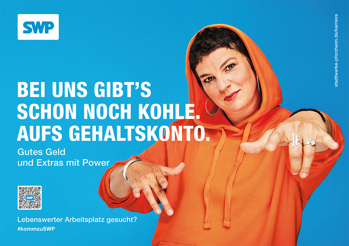 Megalight mit Frau in orangem Hoodie und dem Slogan „Bei uns gibt’s schon noch Kohle. Aufs Gehaltskonto. Gutes Geld und Extras mit Power.“